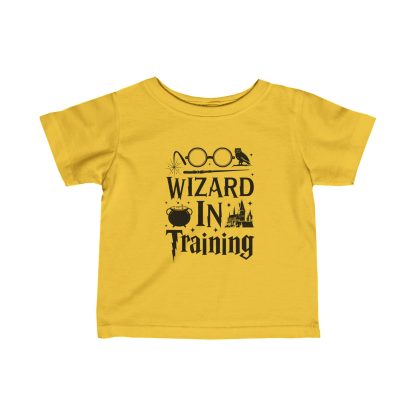 Baby wearing a soft, white 'Wizard in Training' t-shirt, with a magical wand design. The tee is made of 100% combed, ring-spun cotton, featuring a comfortable fit with taped shoulders and ribbed knitting for durability