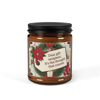 Amber jar candle with "Dear gift recipient, It’s the thought that counts" printed on the label, surrounded by holiday decorations. Available in 9oz size, made with 100% natural soy wax, a cotton wick, and offering a cozy, eco-friendly burn.