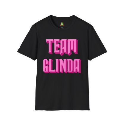 Image of a unisex t-shirt with "Team Glinda" printed in an elegant, whimsical font across the front, accompanied by sparkling star accents for a magical touch. The shirt is made of soft, high-quality cotton and has a classic fit with a crew neckline, designed for comfort and style. It comes in a solid pastel pink color, evoking Glinda's bubbly and charming personality. Ideal for fans of Wicked or anyone who embraces positivity and enchantment.