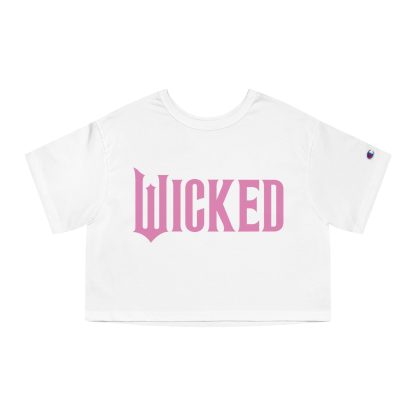 Women's cropped t-shirt featuring a minimalist 'Wicked' design, available in Elphaba's green or Glinda's pink. Made from 100% cotton jersey with the iconic Champion 'C' logo on the sleeve, showcasing a trendy and durable cropped fit perfect for Broadway fans.