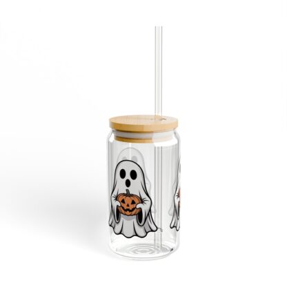 Cute ghost in a white sheet holding a jack-o-lantern on a 16oz sipper glass.