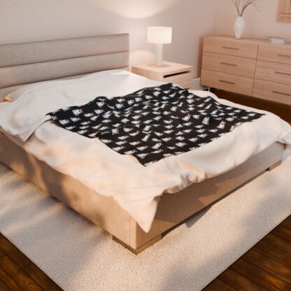 Cute ghosts in a white sheet wearing pink and purple bows on velveteen blanket.