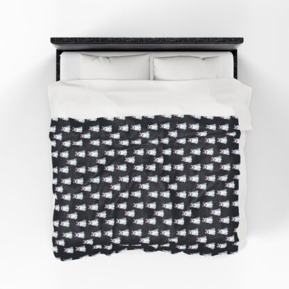 Cute ghosts in a white sheet wearing pink and purple bows on velveteen blanket.