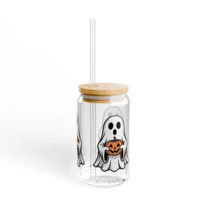 Cute ghost in a white sheet holding a jack-o-lantern on a 16oz sipper glass.